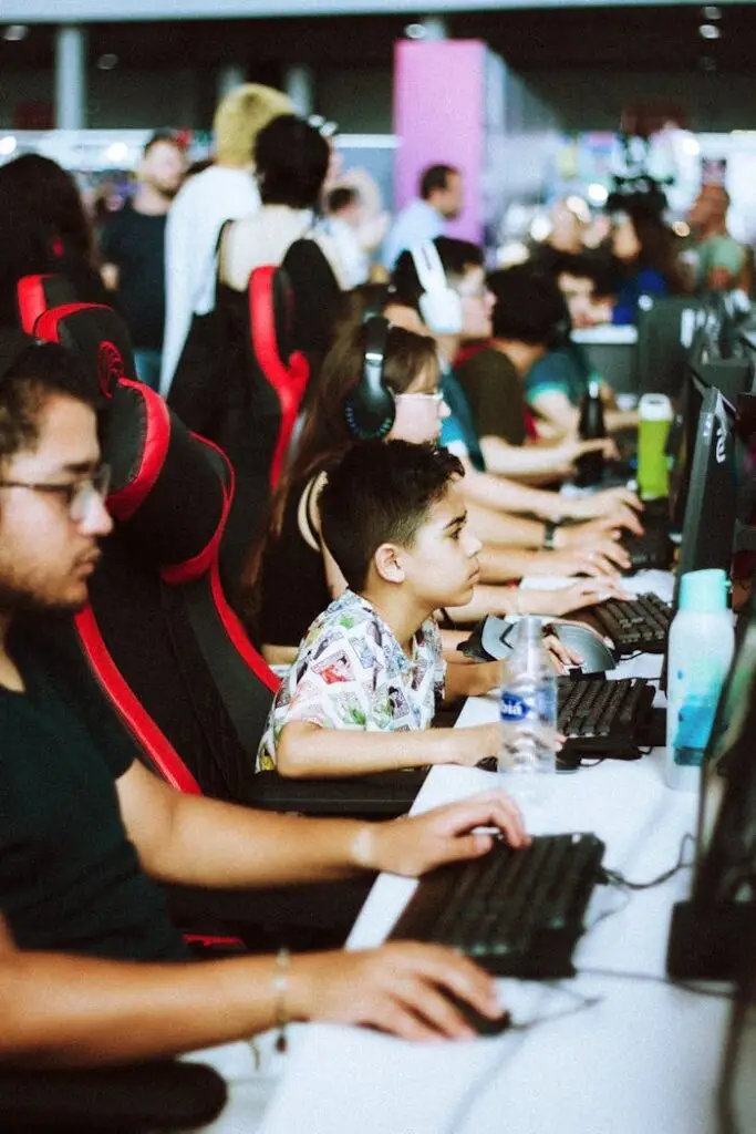 Intense gaming session at an event with diverse participants focused on their screens.