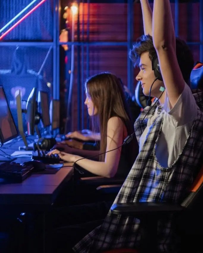 two gamers one celebrating with hands in the air copped